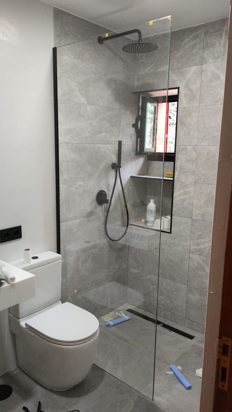 Zona de ducha terminada con la ventana en su nueva posición, hornacina y mampara