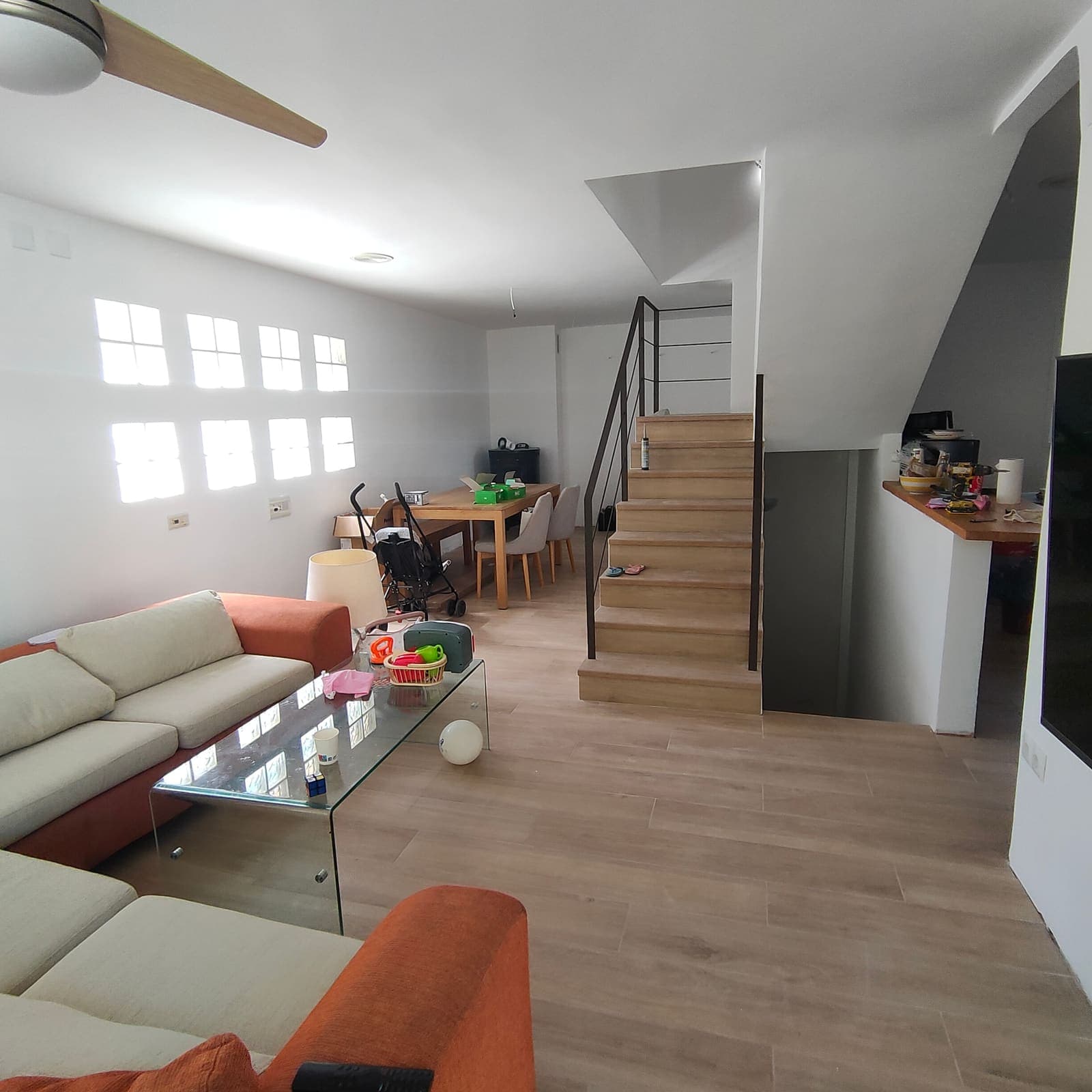 Salón reformado con pavimento nuevo y escalera tras una reforma integral en Ondara, cerca de Dénia