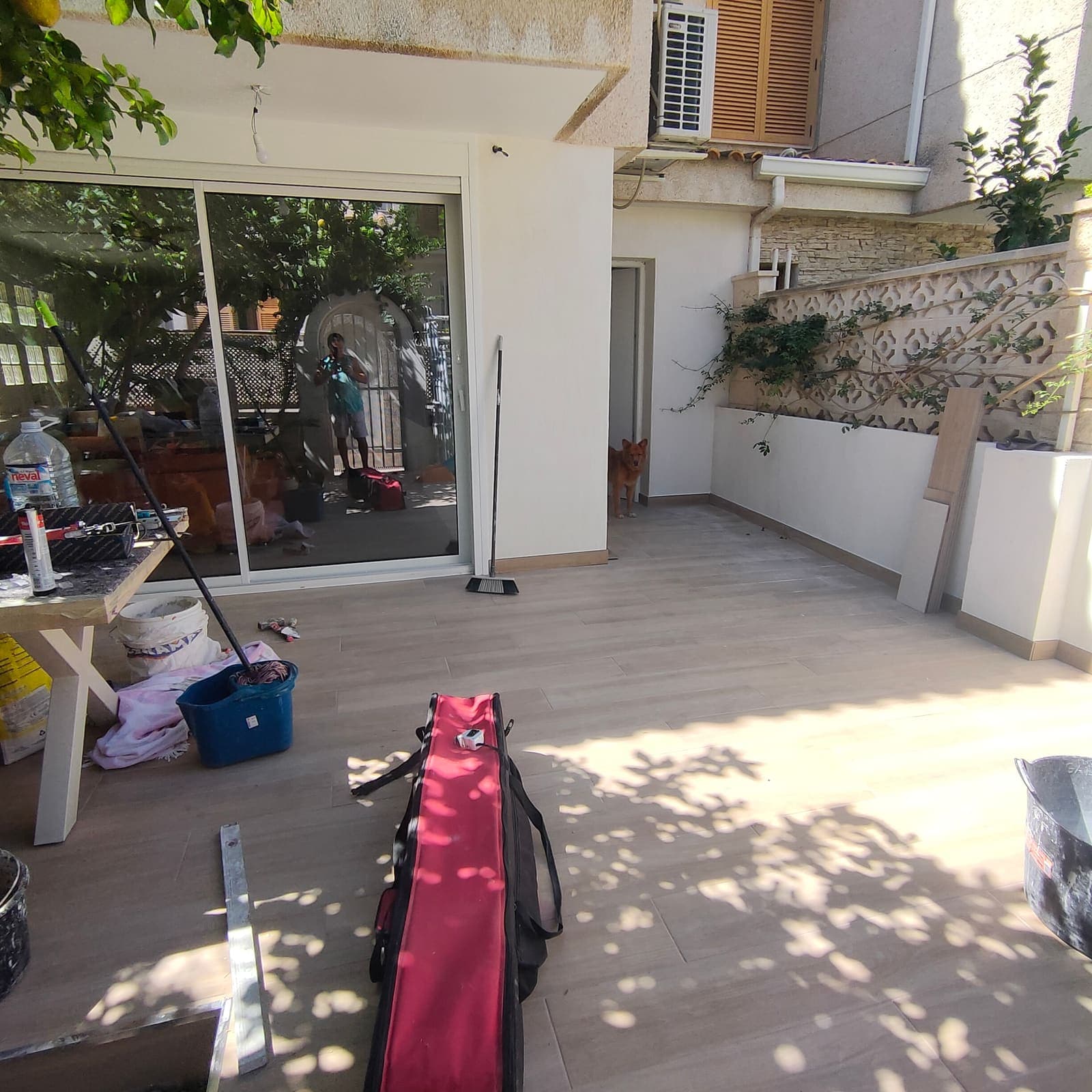Terraza con pavimento porcelánico imitación madera y murete pintado en blanco