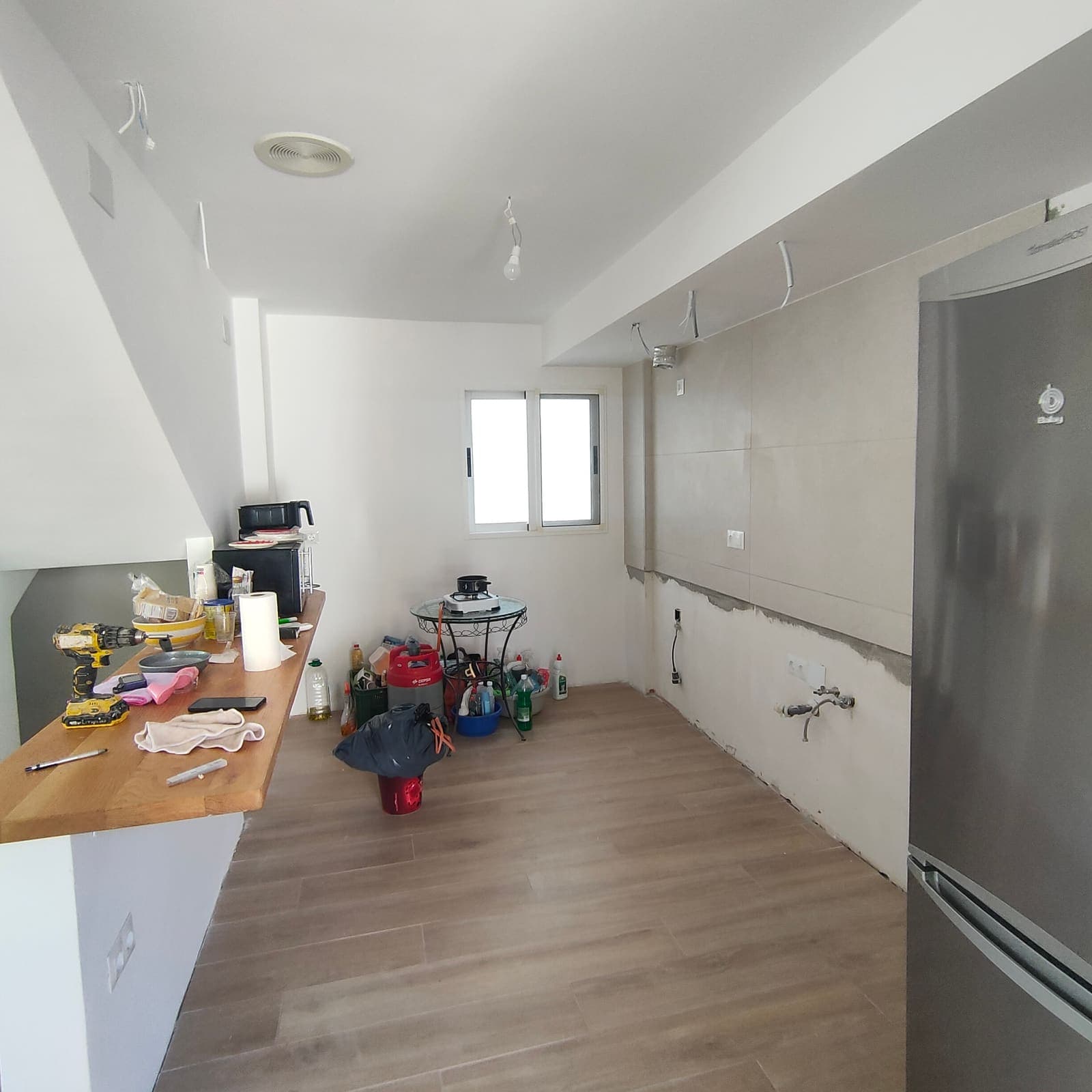 Recibidor reformado con paso abierto hacia la cocina y ventana nueva