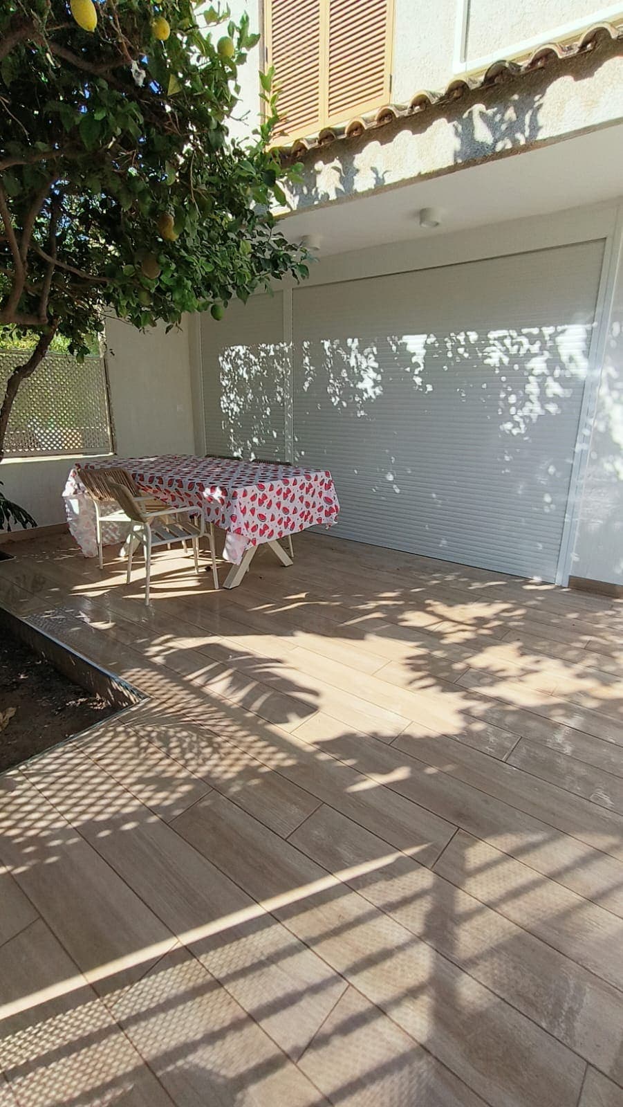 Comedor exterior en la terraza reformada, junto al ventanal del salón