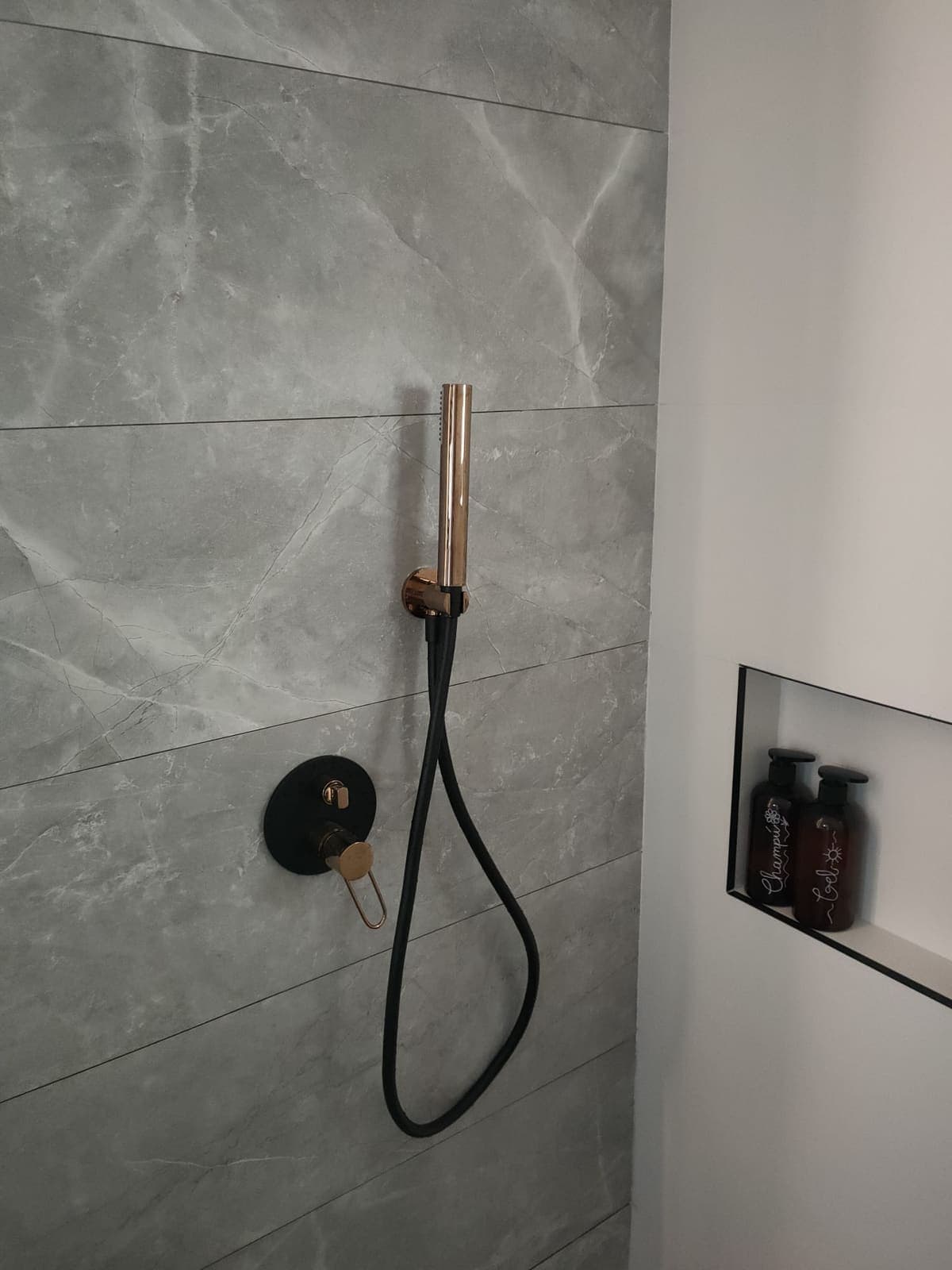 Grifería de ducha empotrada instalada en una reforma de baño en Gandía, con teleducha y hornacina integrada
