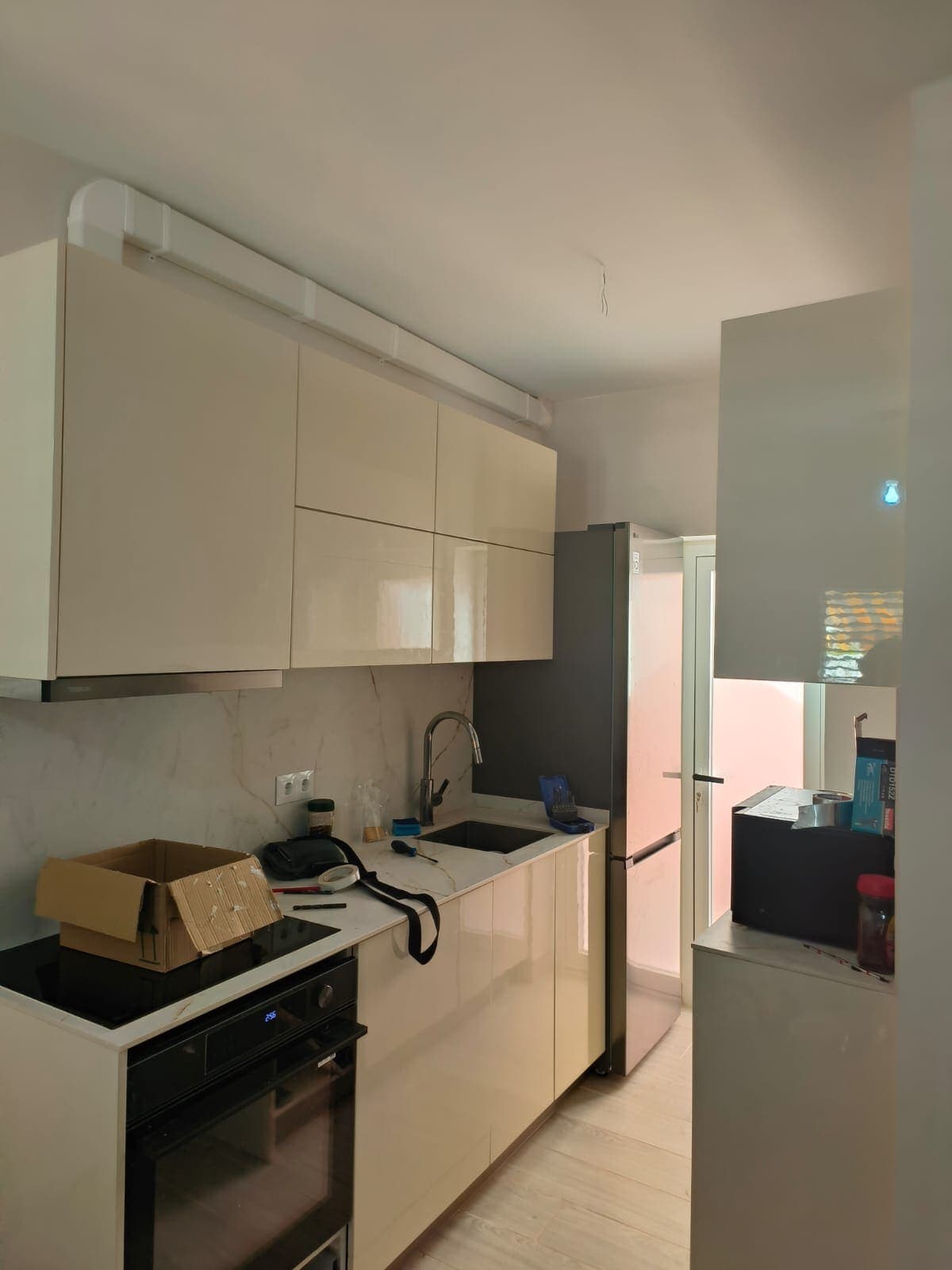 Frente de cocina en Calpe con horno bajo la placa, fregadero y hueco para el frigorífico